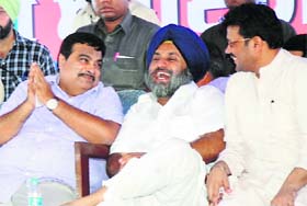BJP president Nitin Gadkari (L) shares a point with Punjab Deputy Chief Minister Sukhbir Badal (C) in Fazilka on Thursday