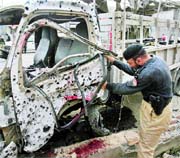 A policeman inspects a vehicle used for transporting police officials after it was hit by a bomb in Peshawar on Thursday.
