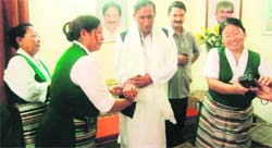 A Tibetan woman ties a rakhi to the wrist of state BJP chief Bishan Singh Chufal in Dehradun