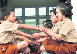 Girls tie rakhi on inmates of the Bal Ashram in Jammu on Friday