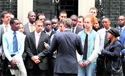 British PM David Cameron (back to camera) with a group of young people, who are taking part in a "Not In Our Name" event, in London on Friday. The London riots have thrown youth into the spotlight and the event is expected to give the city's young people a chance to talk about what has happened