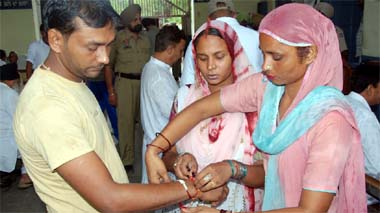 Krishan, an inmate at the Central Jail, Bathinda, watches as his sisters tie rakhi on his wrist to mark the festival of Raksha Bandhan, that was celebrated on Saturday.