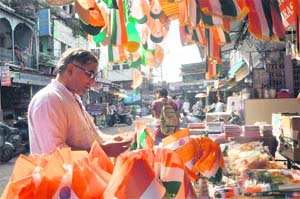 A man buys the National Flag at a shop in Moti Bazar in Dehradun