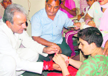 A differently abled woman ties a rakhi on Chief Parliamentary Secretary Prahlad Singh Gillankheras wrist in Fatehabad on Saturday. 