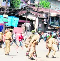 Policemen chase a group of protesters who were hurling stones at them in the Maisuma area of Srinagar on Saturday