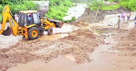 A JCB clears a portion of the GT road in Ludhiana.