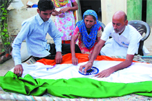 Harpal Gogi gives finishing touches to the Tricolour for hoisting it atop his house at Kot Bakhtu village in Bathinda district on the Independence Day. 