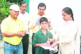 Councillor Jasveer Kaur gives the prize to a winner of the cross-country in Mussoorie on Sunday