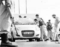 Policemen check vehicles ahead of the Independence Day celebrations, at the Indira Chowk in Jammu on Sunday