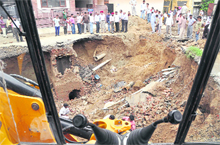The site of a road cave-in that claimed the life of a truck driver in Ludhiana on Friday night. A team led by the Chief Vigilance Officer of the local bodies department can be seen inspecting the area. 