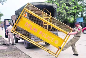 Raising hurdles! Policemen unload barricades from a police vehicle in preparation for Anna Hazares hunger strike in New Delhi on Sunday