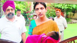 Ritu Agarwal, wife of Deputy Commissioner Rajat Agarwal, holds the baby at Red Cross Bhavan in Amritsar.