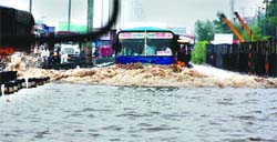 A bus tries hard to negotiate a water-submerged road at Hero Honda chowk after a downpour in Gurgaon
