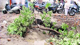 A caved-in portion of a road in Sunder Nagar; A potholed road near Basti Jodhewal.
