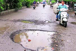 A potholed road near Basti Jodhewal.