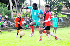 A player tackles another in a match in the Lala Nemi Dass Memorial District Football League in Dehradun on Wednesday. 