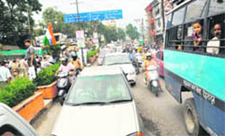 Traffic moves at a snails pace as a procession passes by on the Rajpur Road in Dehradun on Wednesday.