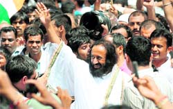 Art of Living guru Sri Sri Ravishankar waves to the crowd outside Tihar Jail in New Delhi on Wednesday