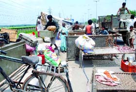 Residents of the Yamuna pusta shift to safety as the water rises.