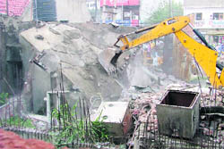 A JCB razes an illegal structure on the Hambran road in Ludhiana. 