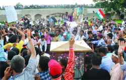 Annas supporters pay tributes to Mahatma Gandhi at the Rajghat in New Delhi before going to the Ramlila Ground.
