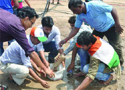 People at Ramlila Maidan try to clear water from the ground on Friday. 