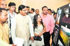 Chief Minister Ramesh Pokhriyal Nishank goes around an exhibition of photographs held on World Photography Day in Dehradun on Friday.