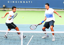 Leander Paes returns as Mahesh Bhupathi stands by in their match against Marc Lopez and Rafael Nadal in Mason, Ohio on Friday