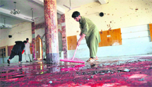 A local resident cleans a mosque after a suicide bomb attack in the town of Jamrud, 25 km from Peshawar, on Friday. 