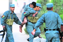 A wounded Afghan policeman is carried away from the site of the attack on offices belonging to the British Council in Kabul on Friday.