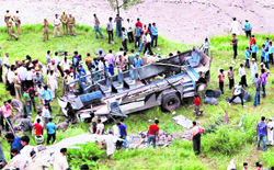 People crowd around a minibus that fell into a gorge in Surankote tehsil in Poonch on Saturday
