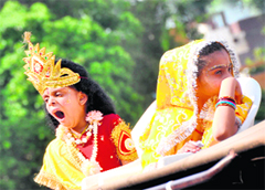 A chid artiste dressed as Lord Krishan breaks into a yawn while another dressed as Radha looks the other way during a Shobha Yatra in Ludhiana. 