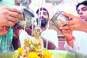 Devotees bath an idol of Lord Krishna in Amritsar on the eve of Janmashtami on Sunday