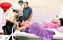 Two women lie on the same bed at the Civil Hospital in Ludhiana, where Civil Surgeon HS Bali disburses cheques under the Mata Kaushalya Yojna