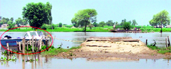 A BSF (in circle) boat keeps a vigil against intrusion in the border village of Mohar Jamsher; and (below) officials distributing medicines at Sangra village in Mand area