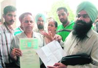 Jet immigration victims show documents to mediapersons at Phase 5 Mohali