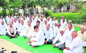 Residents of HUDAs Sector 23 sit on a dharna outside the SDMs office in Sonepat.