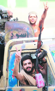 Libyan rebels celebrate as they drive through Tripoli's Qarqarsh district 