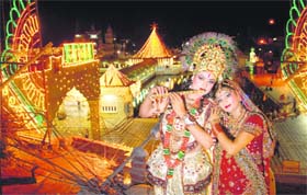 Glimmering Lord Krishna: A girl and a boy pose as Radha and Krishna on Janmashtami in an illuminated Devi Talab Mandir on Monday