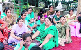 Members of the Multipurpose Health Workers’ Union stage a dharna outside the Health Minister’s residence in Ludhiana on Monday