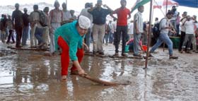 A supporter of Anna Hazare clears water at the Ramlila Ground in New Delhi on Tuesday.