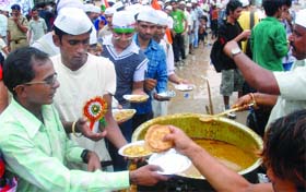 Workers distribute food to the supporters of Anna Hazare during his hunger strike at the Ramlila Ground in New Delhi on Tuesday.