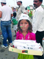 A girl sells Main Anna hun caps at the Ramlila Ground in New Delhi.