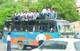 Precariously Placed: Having a scant regard for the risk to the human lives and throwing traffic rules to the wind, a private transporter ferries passengers atop his vehicle in Bathinda while traffic policemen deployed on the spot turn a blind eye