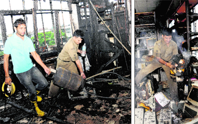 Fire-fighters take out an LPG cylinder; and (right) a firemen beside the burnt records at the Punjab National building in Sector 17, Chandigarh, on Wednesday