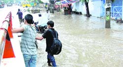 Residents wade through rainwater after heavy downpour in Sirsa 