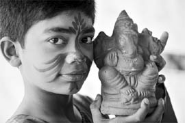 A student poses with a clay idol of Lord Ganesha at an ecological painting workshop in Hyderabad 