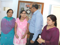 Principal Dr BB Sharma offering sweets to PU topper Nishu Mittal. 