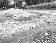 Commuters ply on a damaged road at Sector 6 in Panchkula. 