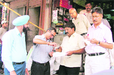 Officials of the Punjab Pollution Control Board check the quality of polybags at a shop in Field Ganj, Ludhiana, on Thursday. 